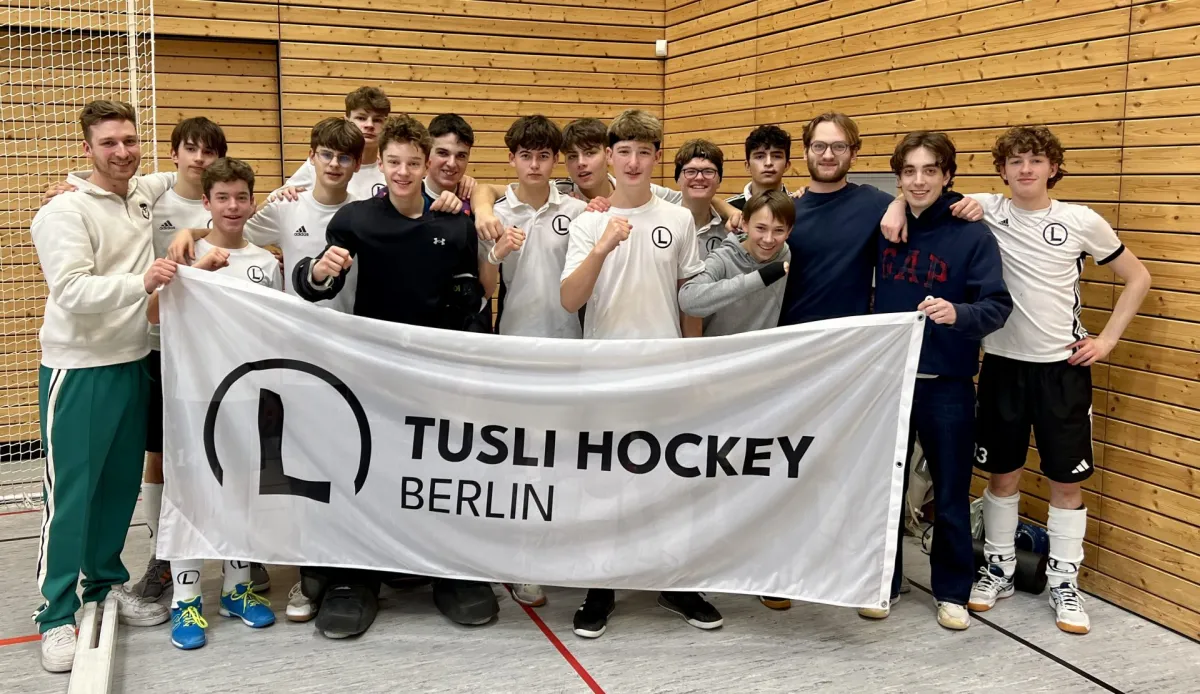 Eine Hockeymannschaft mit einem Banner des Vereins