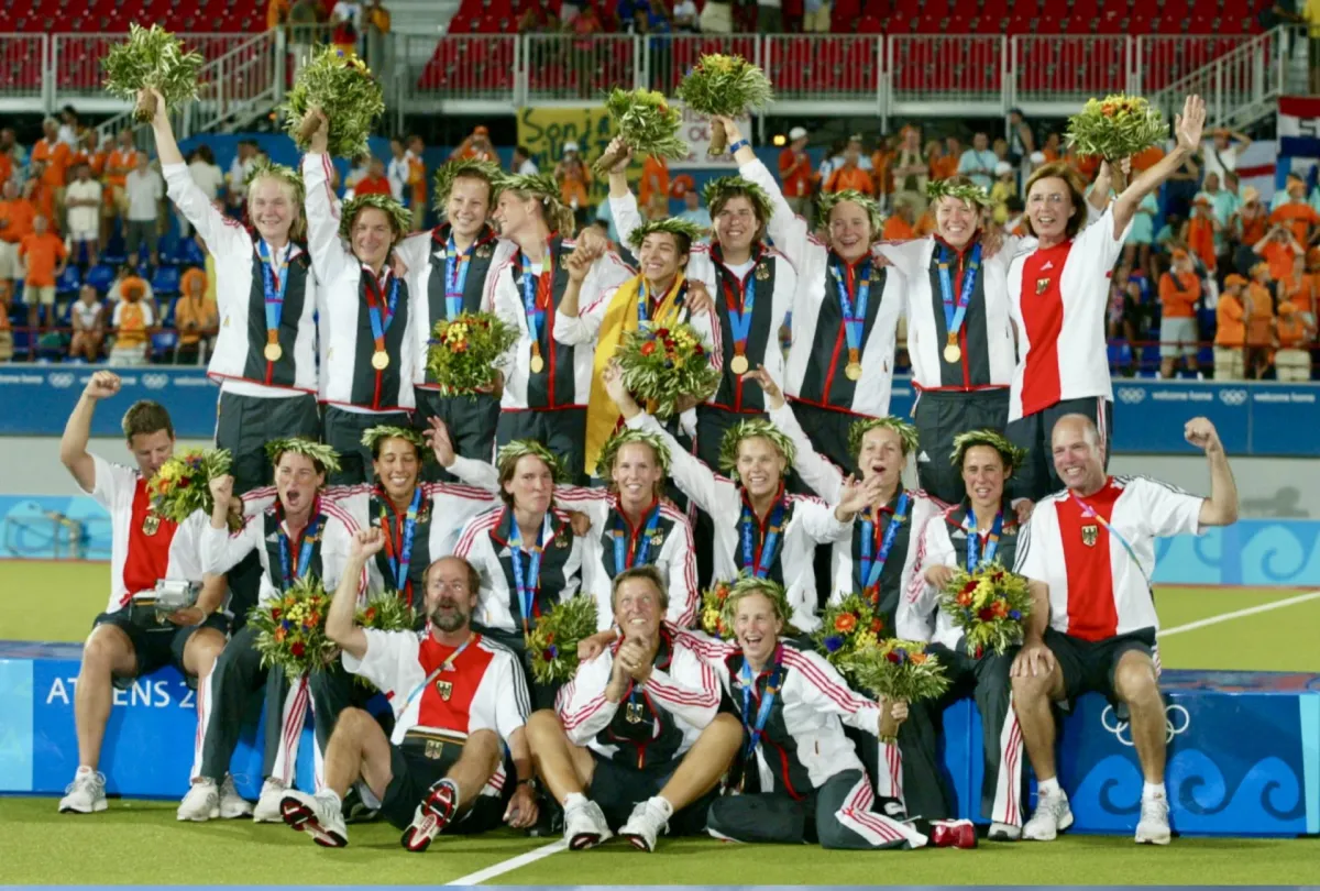 Die deutschen Hockeydamen bei den Olympichen Spielen 2004 feiern ihre Goldmedaille auf dem Siegerpodest